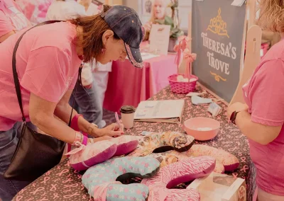 An Expo attendee writing information on a piece of paper at a booth.