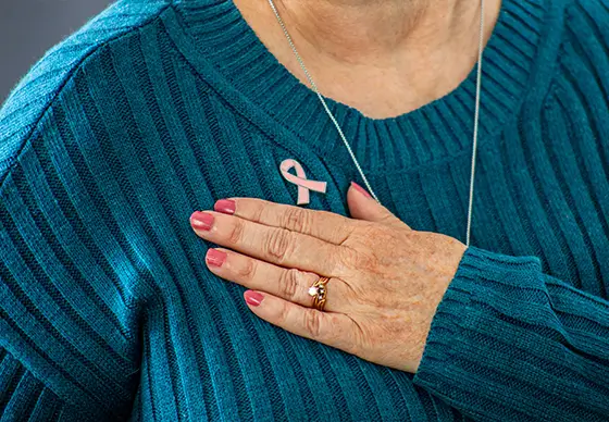 Woman wearing pink ribbon pin<br />
