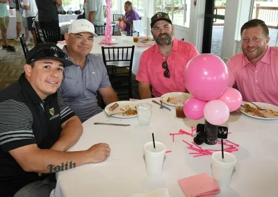 Four golfers eat lunch at a table