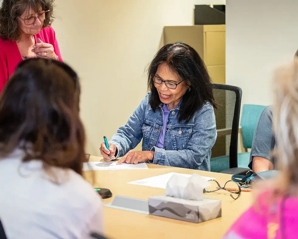 Woman signing in at start of support group