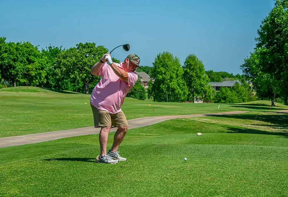 A man swinging his golf glub