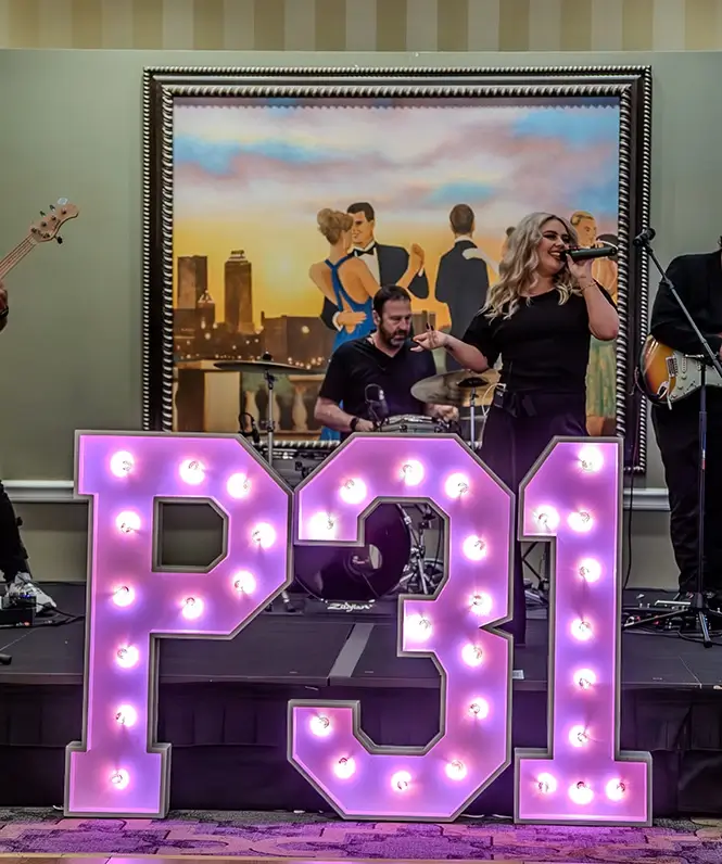 Singer standing on stage behind a P31 marquee