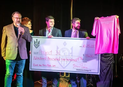 OEFC officials holding a large donation check on stage