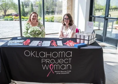 Two women sit at an Oklahoma Project Woman booth