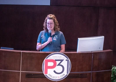A Project31 staff member speaks at a podium