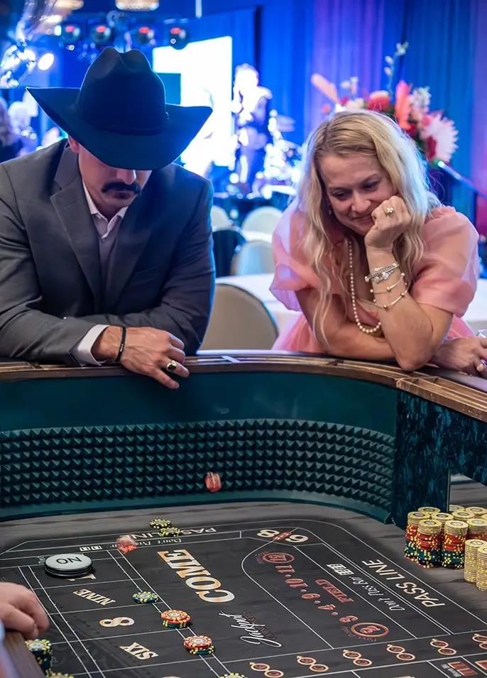 Man and woman playing casino games at Paint the Town Pink