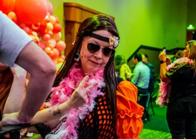 A woman dressed as a hippie gives a peace sign
