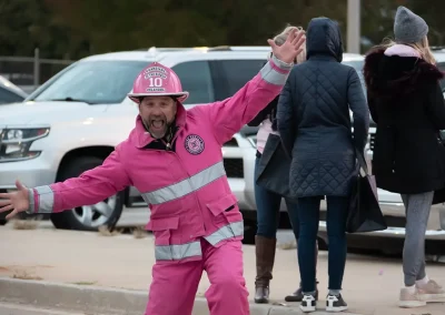 A man wears a pink firefighter suit