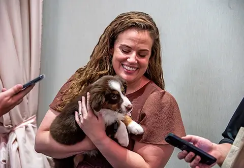 Woman holding puppy at Project31 event