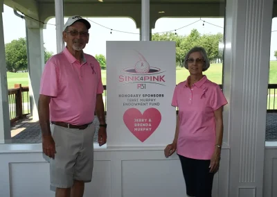 Two Sink4Pink sponsors stand next to their sign