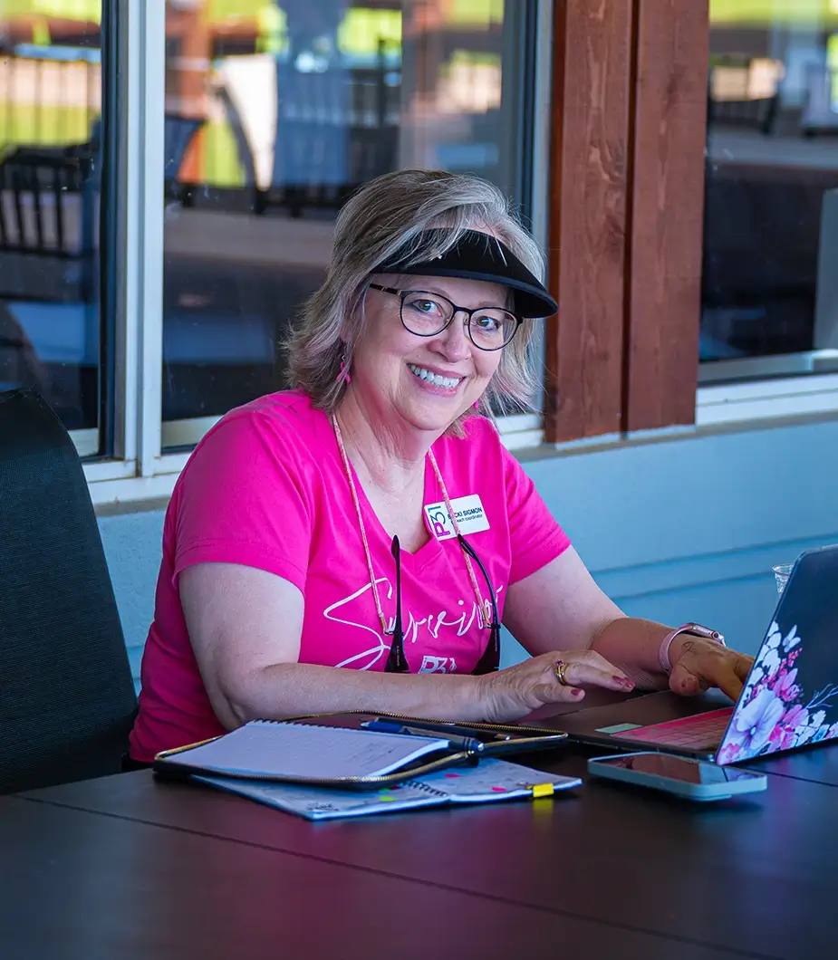 A Project31 team member typing on her computer at the golf tournament