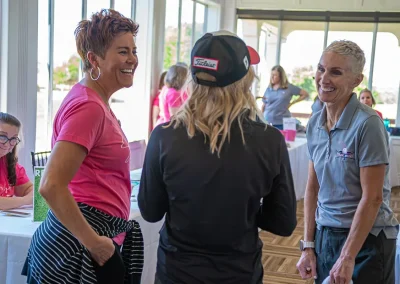 Three women laugh while chatting together