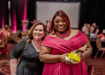Two women in dresses smile