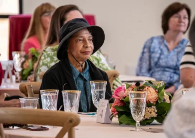 A survivor listens to a speech at a table