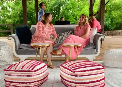 Two women chat on a small sofa