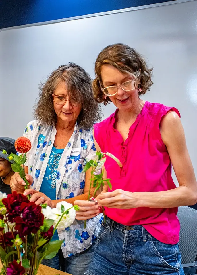 Two breast cancer survivors making a floral bouquet