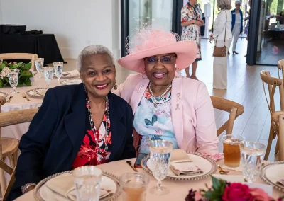 Two friends smile while sitting at a table