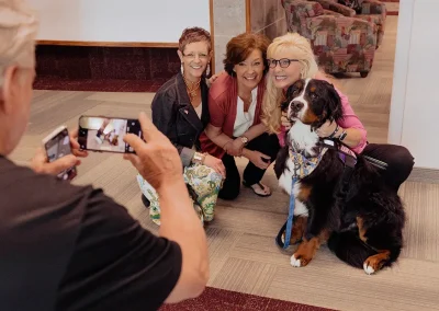Three Women take photo with a large dog
