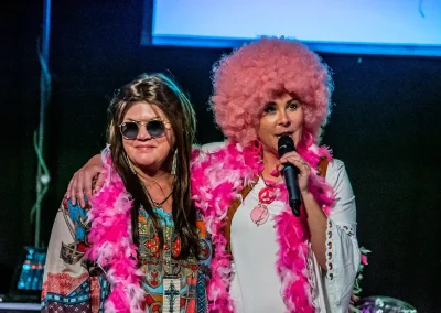 Two women in costume talk on stage